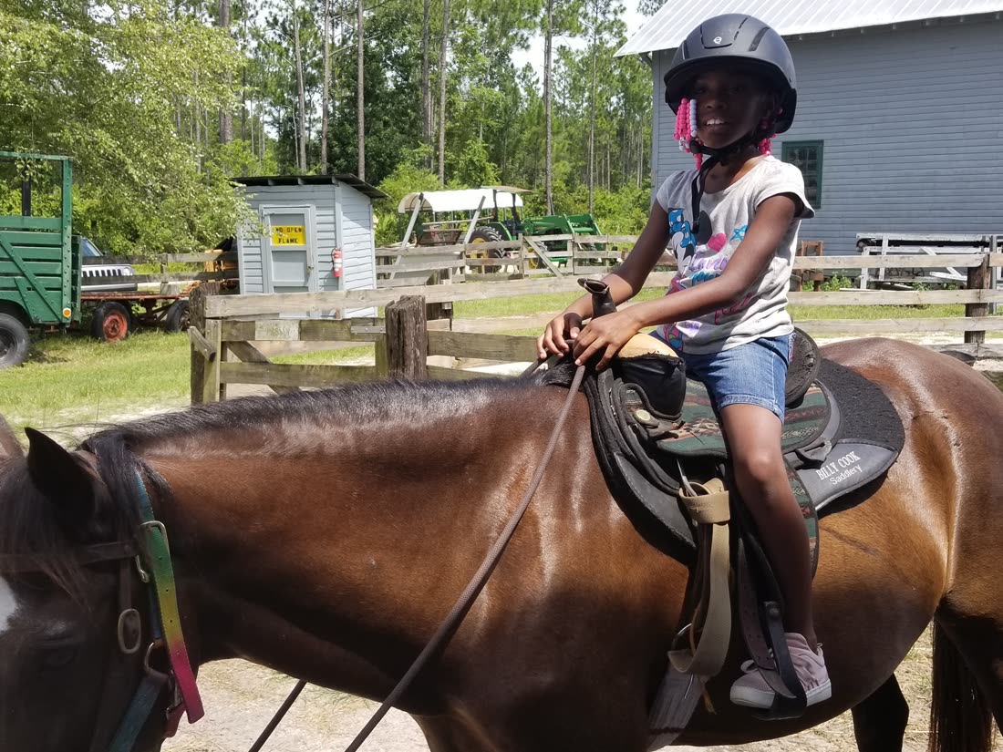 A young rider enjoying a community horseback day